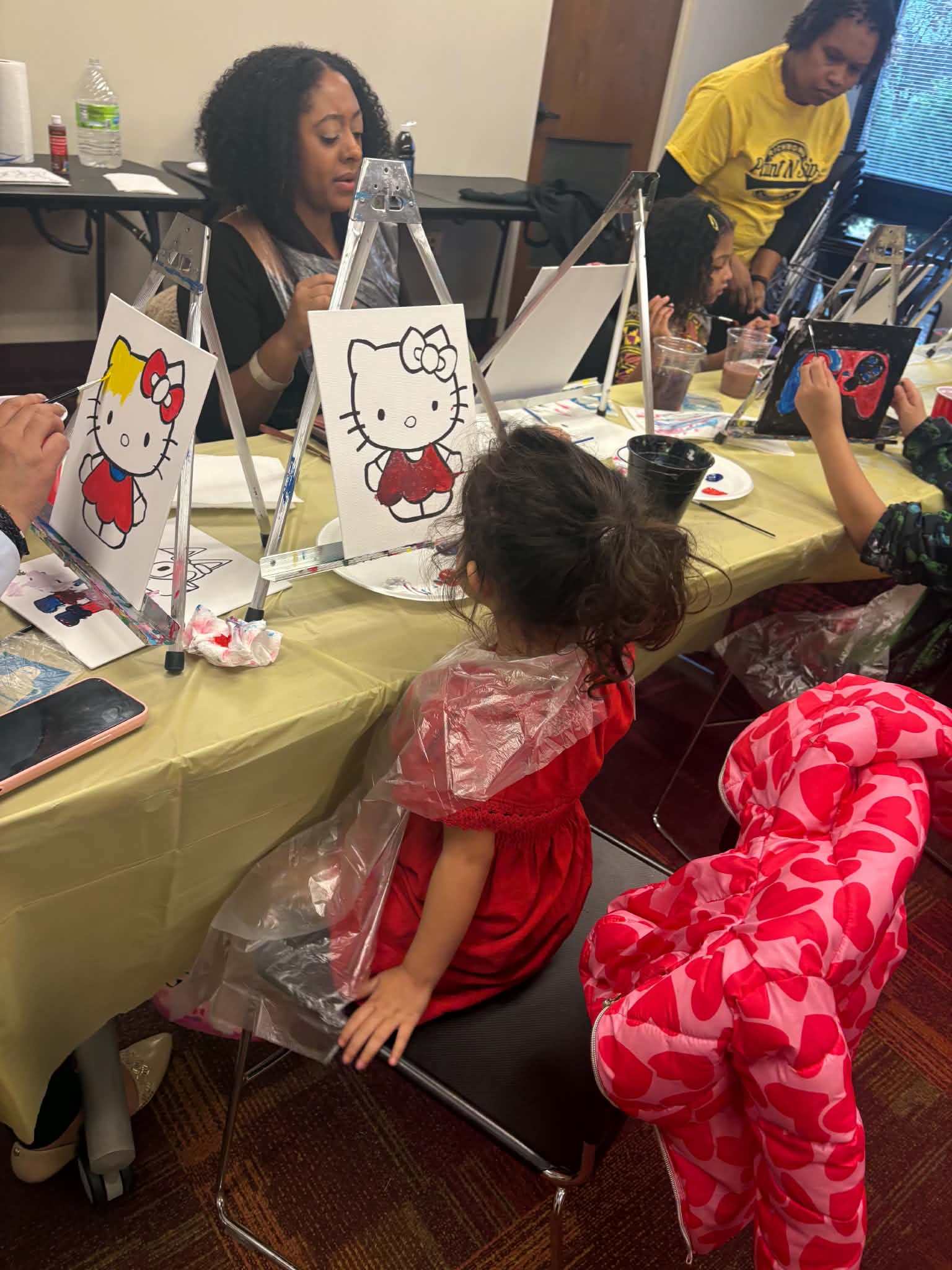 Children working at tabletop easels during an indoor art workshop.