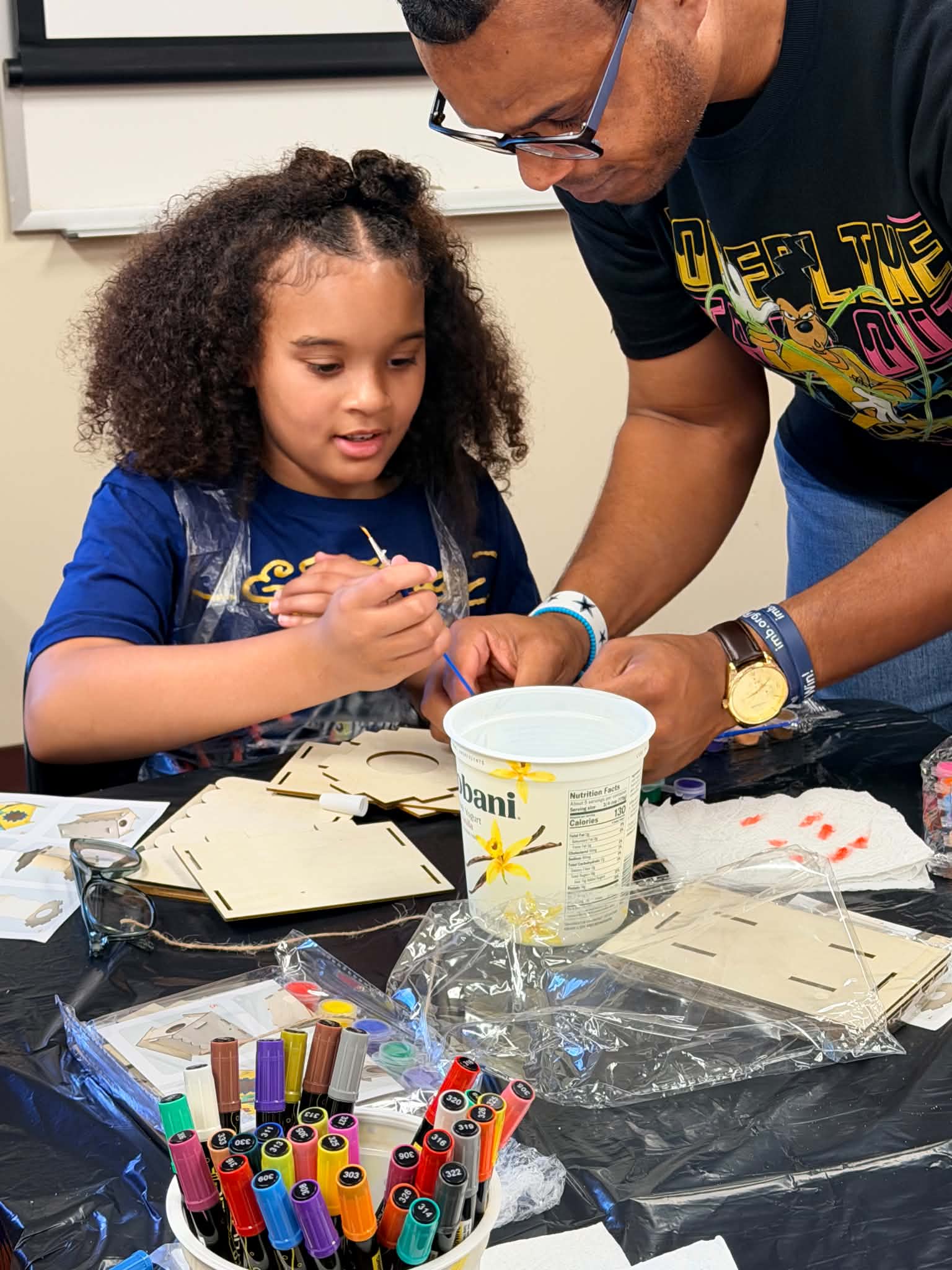 A child receiving hands-on guidance during a Rising Up Now art activity.
