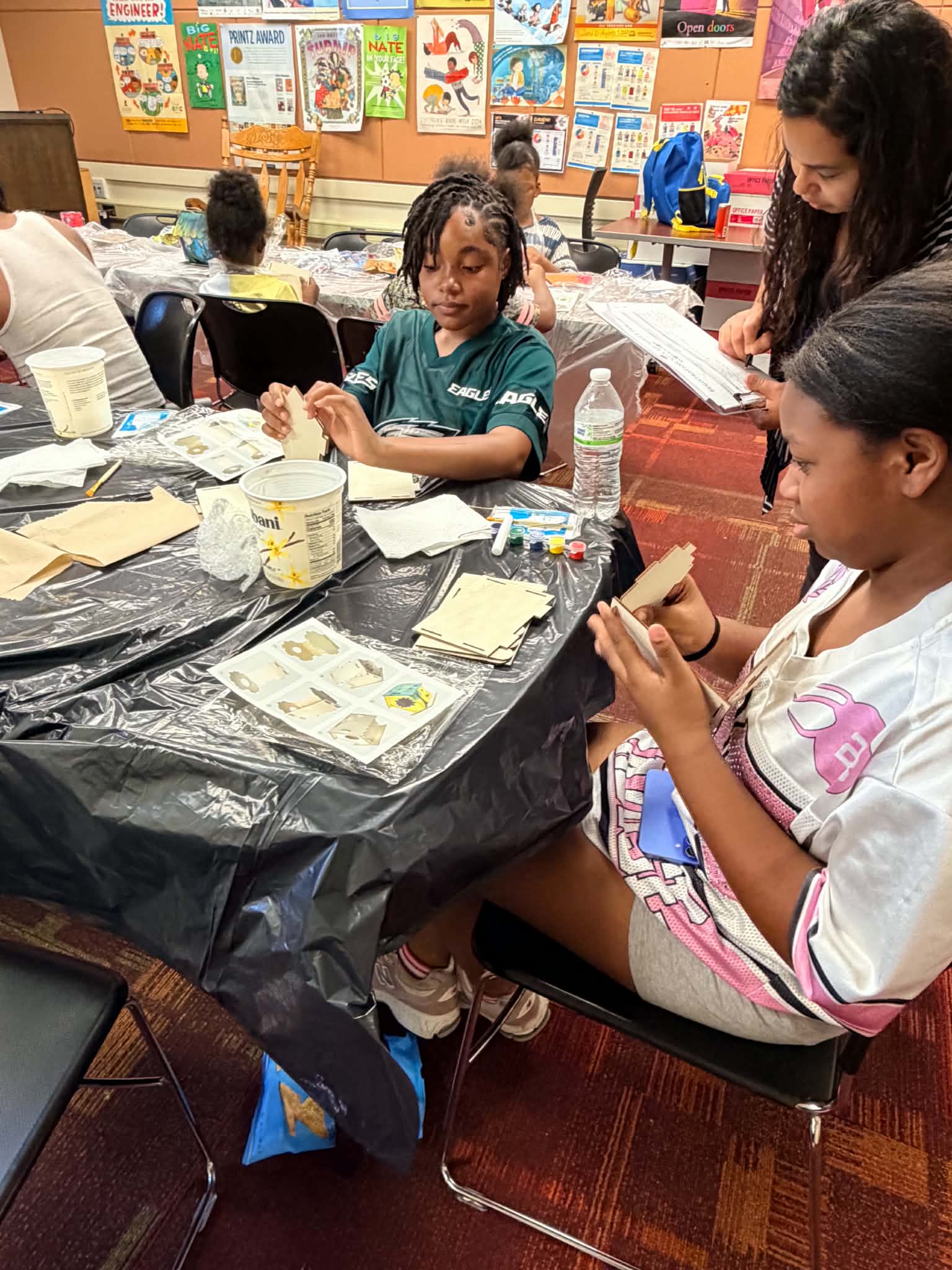 Children painting at a table while working alongside one another during an art workshop.